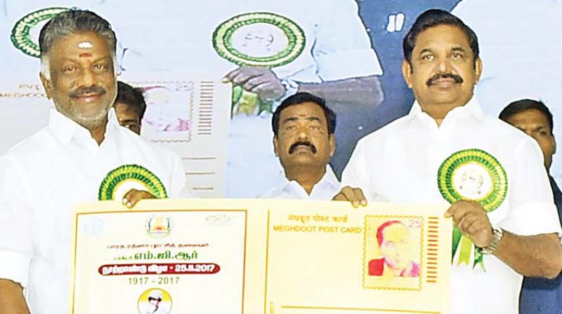 Chief Minister Edappadi K. Palaniswami releases a special postcard commemorating the birth centenary of AIADMK founder and former CM M. G. Ramachandran at a function in Ramanathapuram district on Saturday. Deputy Chief Minister O. Panneerselvam receives it. (Photo: DC)