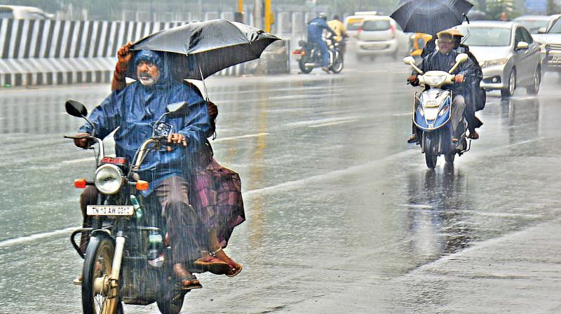 Motorists protect themselves using umbrellas after short spells lashed several parts of the city. (Photo: DC)