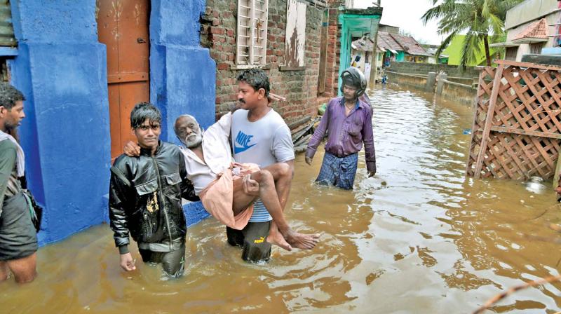 An elderly person is carried to safe place in a flooded locality following a heavy storm at Nagercoil in Kanyakumari district on Thursday. (Photo: DC)