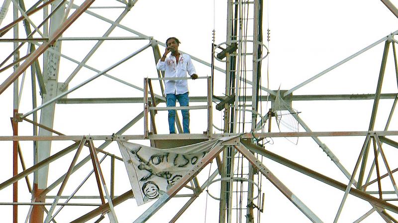 A man creates a flutter by climbing atop a mobile phone tower near Pattinapakkam on early Thursday morning to apologise to his estranged girlfriend. (Photo: DC)