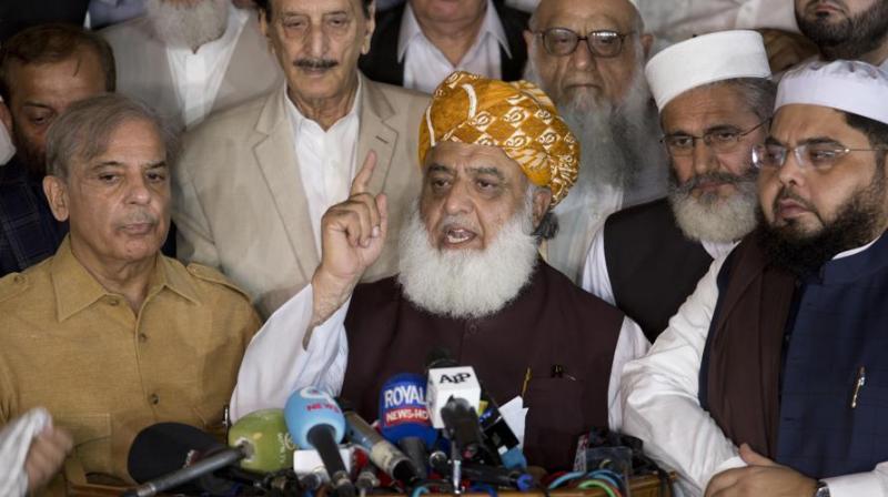Maulana Fazlur Rehman, center, head of Pakistani religious parties alliance surrounds by Pakistani politicians addresses a news conference after the All Parties Conference (APC) in Islamabad, Pakistan, Friday, July 27, 2018. (Photo: AP)
