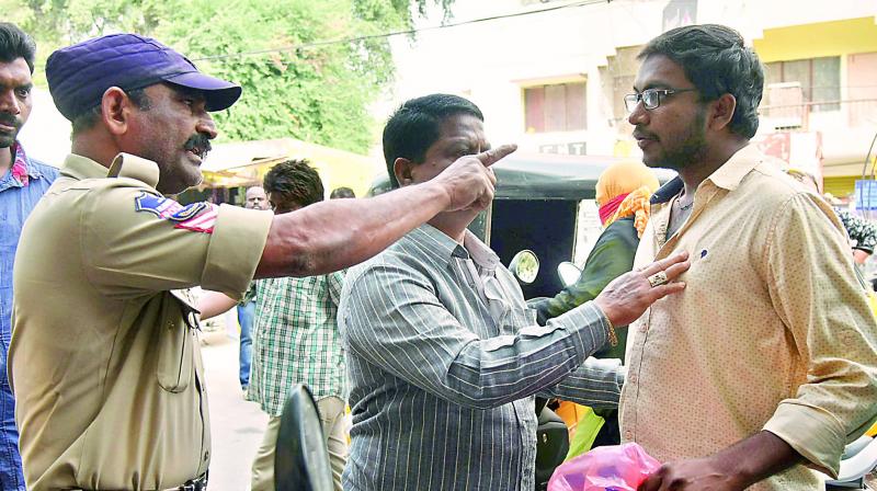 A customer argues with a cop outside a bank at Padmaraonagar (Photo: DC)