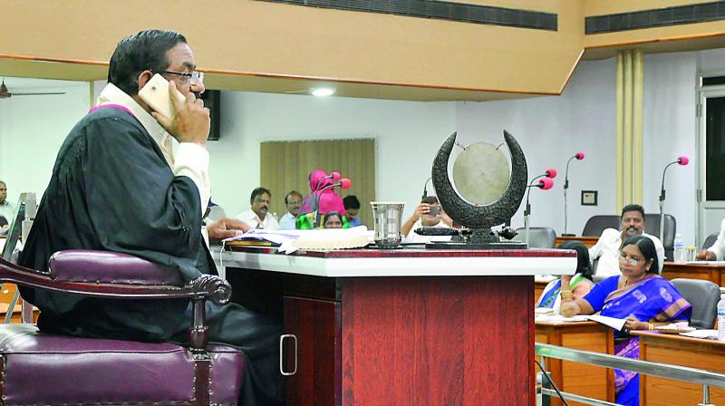 Mayor Koneru Sridhar takes a break from the Council proceedings by attending a phone call in Vijayawada on Tuesday. 	 deccan chronicle