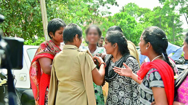 Women police officers and other officials coerce a rescued child labourer (blurred)  to go to the Nimboliadda shelter home for girls on Tuesday.   (Photo: DC)