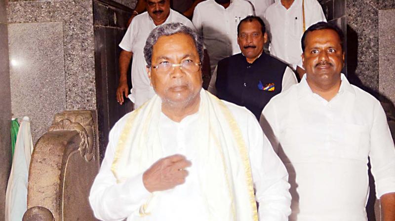 Chief Minister Siddaramaiah and minister U.T. Khader coming out of Dharmasthala temple