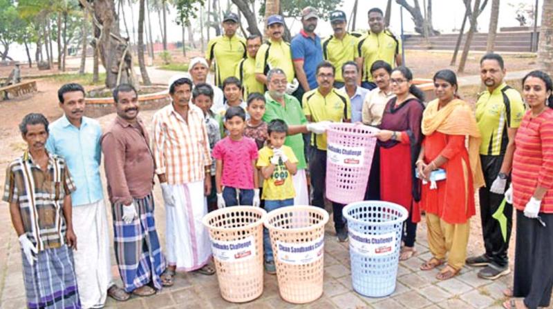 Vadakara municipality secretary K.U. Bini hands over waste bins at Sandbank in Vadakara