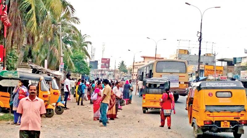 People stand on road due to absence of bus shelter at Iyyappanthangal. (Photo: DC)