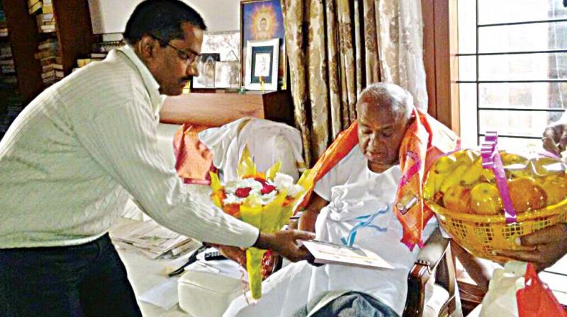 Assistant Commissioner of Hassan sub-division Nagaraj Hassanamba inviting JD(S) chief H.D. Deve Gowda in Bengaluru on Saturday to visit Hassanamba temple in Hassan (Photo: DC)