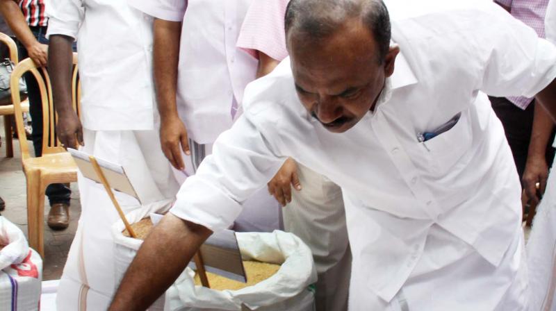 Minister for Food and Civil Supplies P. Thilothaman checks the quality of rice before inaugurating a rice shop at Thirunakkara in Kottayam on Saturday. (Photo: Rajeev Prasad)