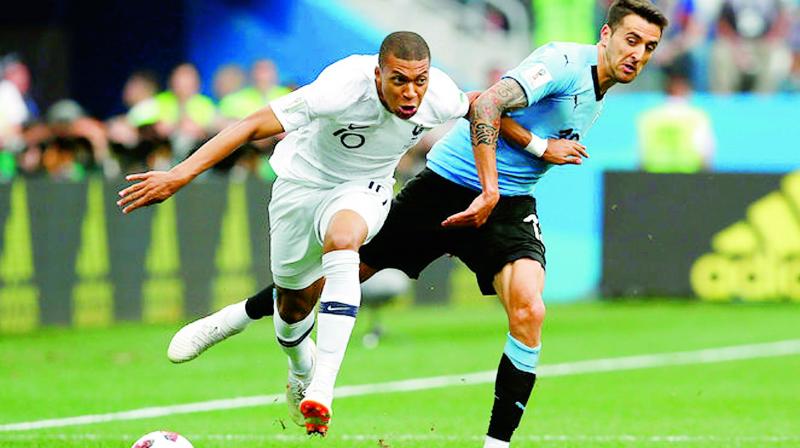 Frances Kylian Mbappe and Uruguays Matias Vecino during the quater-final match between the two teams.