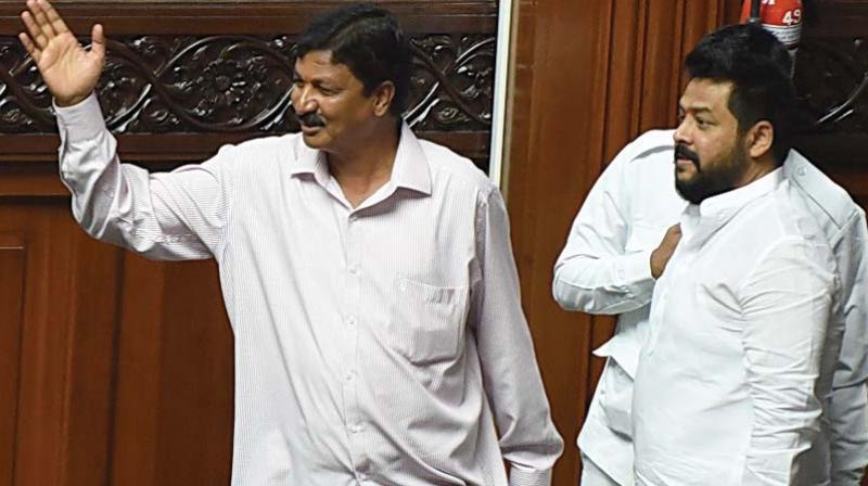 Rebel Congress MLAs Ramesh Jarkiholi and B. Nagendra after they arrived in the legislature to attend the proceedings on Wednesday.