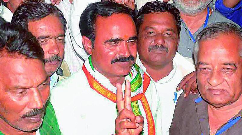 Congress candidate Brijendra Singh Yadav with his supporters flashes victory sign after winning Mungaoli bypolls Assembly elections, in Ashok Nagar District Madhya Pradesh on Wednesday. 	 PTI