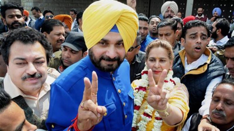 Congress candidate from Amritsar East assembly constituency Navjot Singh Sidhu with his wife posing with victory signs. (Photo: PTI)