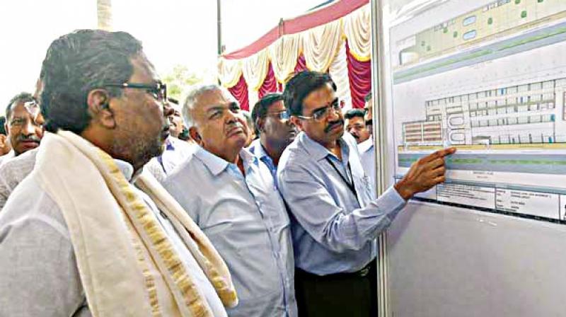 A file photo of CM Siddaramaiah looking at the blueprint of the car parking facility at Freedom Park in Bengaluru.