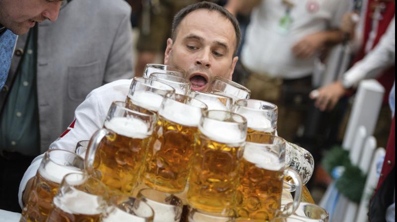 Oliver Struempfel competes during his world record attempt, carrying 27 beer mugs at the traditional festival Gillamoos in Abensberg, Germany. He succeeded. (Photo: AP)