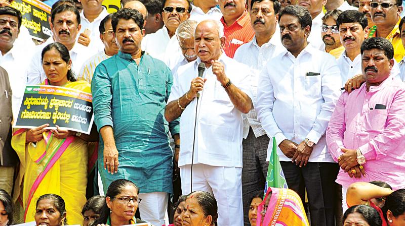 BJP workers led by state president B.S. Yeddyurappa protest against the corrupt practices of the state government at Town Hall in Bengaluru on Monday.