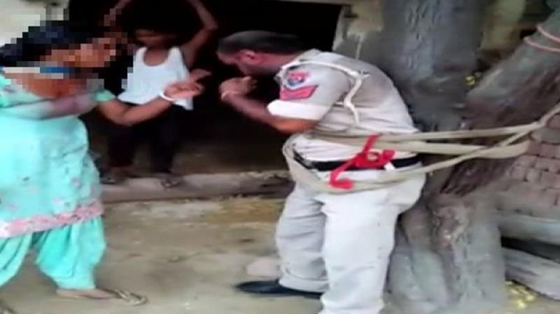 In a video, the policeman is seen tied to a tree and being beaten up severely by a woman who alleged that the policeman tried to rape her in an inebriated condition. (Photo: ANI)