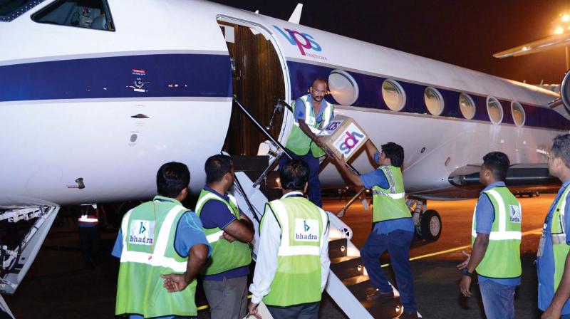 Workers unload a consignment of protective gear from a private jet in Kozhikode on Saturday.