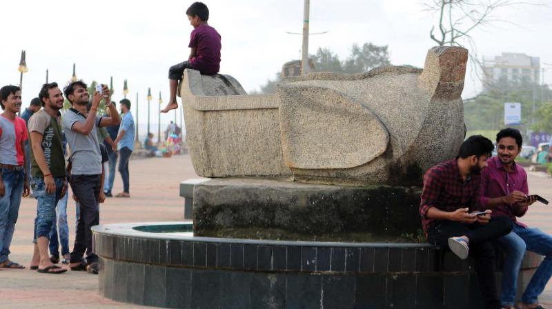 Art for comfort sake: A group of youngsters take the photograph of a child who is  sitting over a sculpture at Beach, Kozhikode.