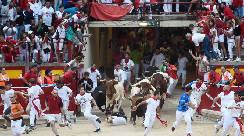 Revellers take part in Spains annual bull-running fiesta