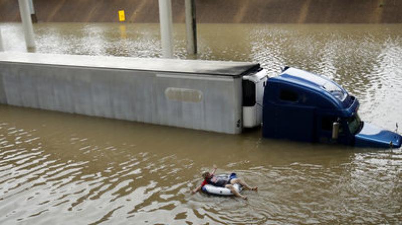 After helping the driver of the submerged truck get to safety, a man floats on the freeway flooded by Tropical Storm Harvey on Sunday, near downtown Houston. (Photo: AP)