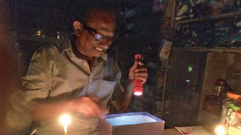 A pharmacist at Chitlapakkam in Chromepet works with torch light and candles on Thursday. Several parts of Chennai continue to remain in darkness after cyclone Vardah snapped power lines and uprooted electricity poles. Citizens in some parts held demonstrations against the slow pace of power restoration. (Photo: DC)