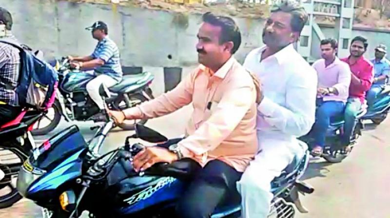 Telangana state excise minister T. Padma Rao rides pillion on his friends bike in the city on Tuesday. (Photo: DC)