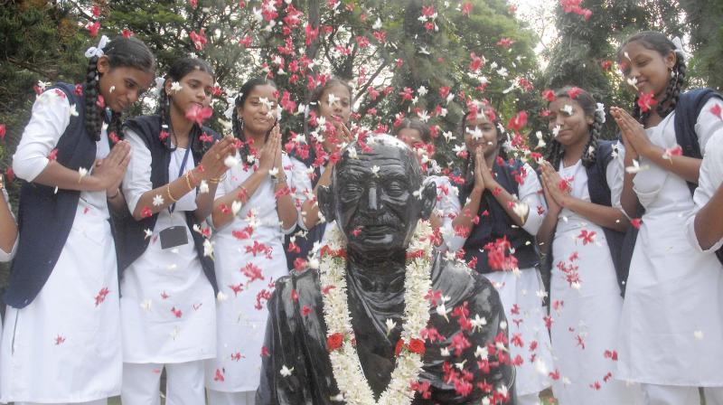 Students garland the statue of Mahatma Gandhi during the Gandhi Jayanti celebration on MG Road in Bengaluru on Tuesday  (Image DC)