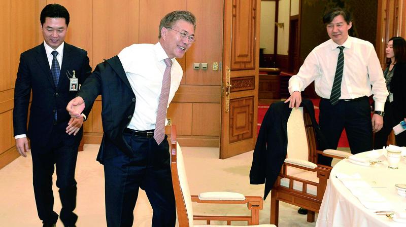South Korean President Moon Jae-in takes off his jacket at the presidential Blue House in Seoul, South Korea on Thursday. South Korean internet users have shared photos of Moon waving off a presidential employee and taking off his own jacket at a luncheon, projecting an image that hes a down-to-earth President. (Photo:AP)