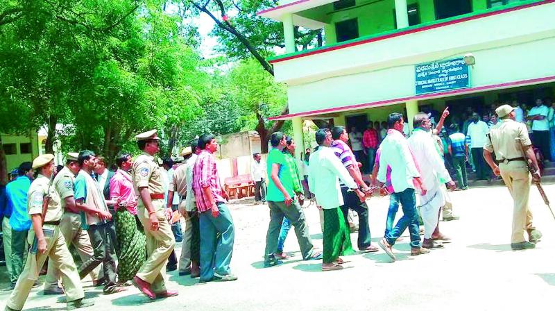 Handcuffed chilli farmers are being taken to the court complex in Khammam. (Photo: DC)