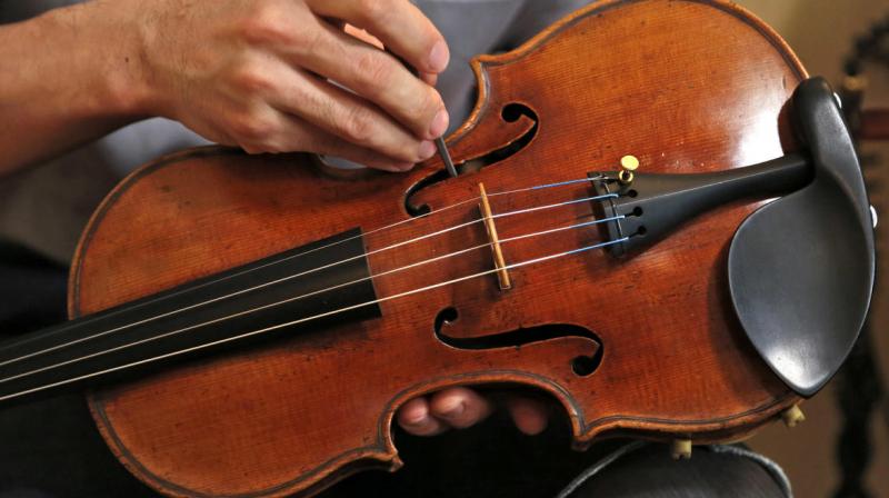 Tatsuo Imaishi makes an adjustment on the Ames Stradivarius violin in New York. (Photo: AP)