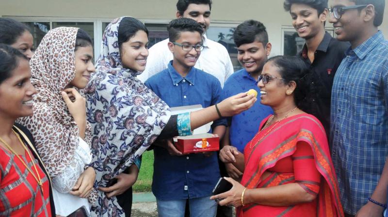 Students of Greets Public School, Kaloor, offer sweets to their principal Jaya Sabin to celebrate hundred percent victory for the school in the CBSE board exam in Kochi on Tuesday. (Photo: ARUN CHANDRABOSE)