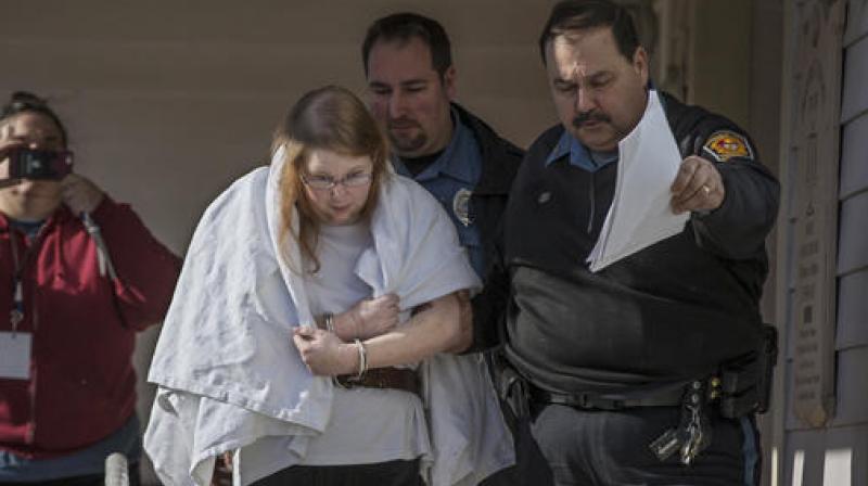 Sara Packer, center, handcuffed, the adoptive mother of Grace Packer, was led out of District Court in Newtown. (Photo: AP)