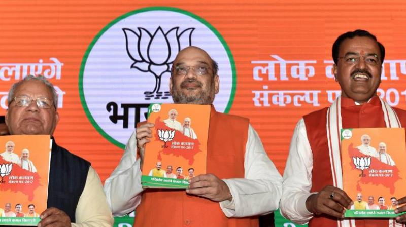 BJP President Amit Shah with UP BJP chief Keshav Prasad Maurya releasing party manifesto for the upcoming Uttar Pradesh assembly elections in Lucknow. (Photo: PTI)