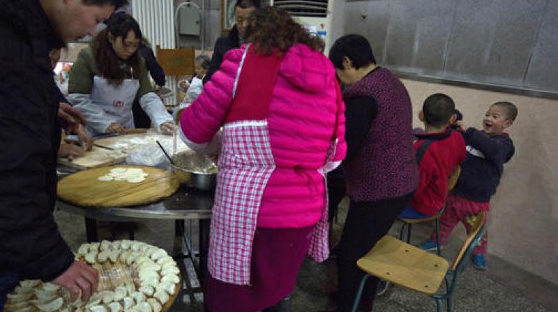Children play as villagers gather to make dumplings ahead of the Chinese lunar new year at a village on the outskirts of Beijing. (Photo: AP)