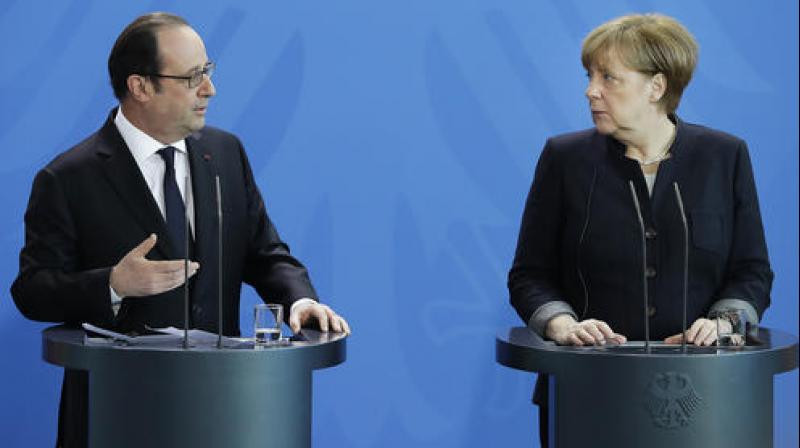 French President Francois Hollande with German Chancellor Angela Merkel during a joint statement as part of a meeting at the chancellery in Berlin. (Photo: AP)