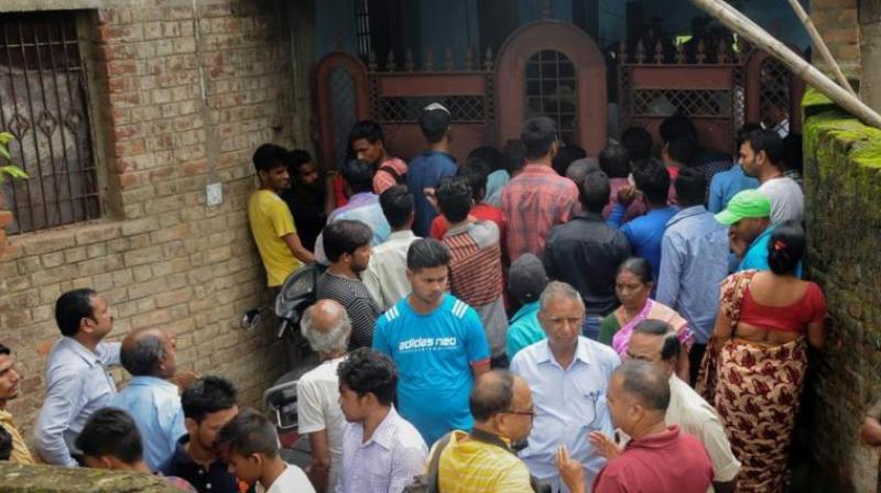 People gather outside the house where seven members of a family allegedly committed suicide, in Ranchi on Monday, July 30, 2018. (Photo: PTI)