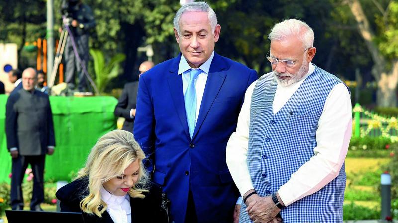 Sara Netanyahu, wife of the Prime Minister of Israel, Benjamin Netanyahu signing the visitors book, at Teen Murti Haifa Chowk, in New Delhi on Sunday. Prime Minister Narendra Modi looks on. (Photo: PTI)