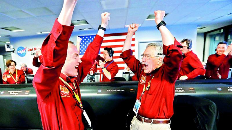 Nasa engineers react after the successful landing by the InSight spacecraft on the planet in California on Tuesday. 	AP
