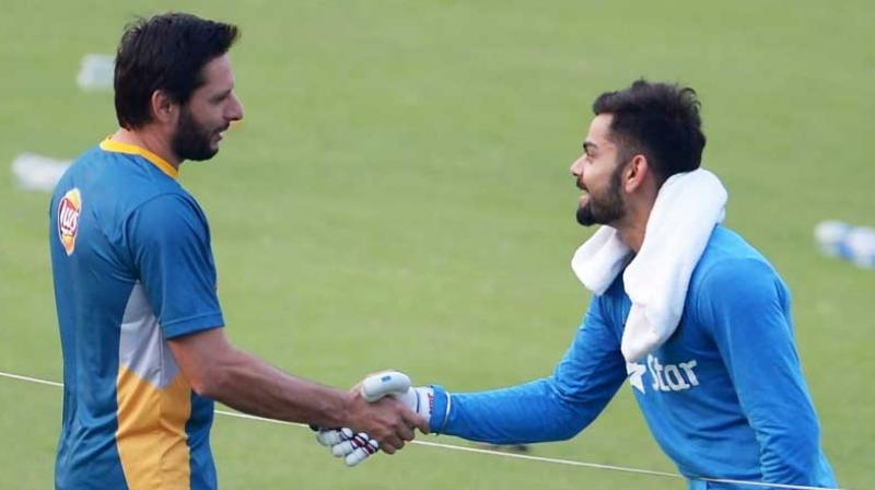 The Indian cricket team presented a Virat Kohli shirt, signed by all the players, to Shahid Afridi on retiring from the international cricket. (Photo: AFP)