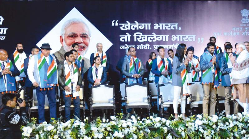 Prime Minister Narendra Modi greets Pullela Gopichand and P.V. Sindhu at the launch of the Khelo India School Games in New Delhi on Wednesday. (Photo: Sondeep Shankar)