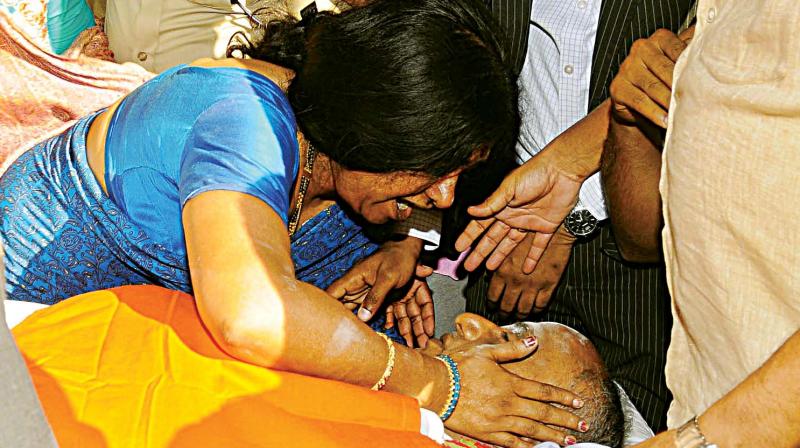 Wife Dr Geetha is inconsolable as she grieves beside the body of Minister Mahadev Prasad.(Below) Chief Minister Siddaramaiah and his colleagues condole his death