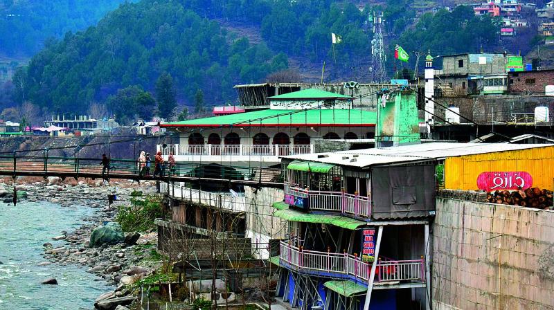 Pakistan villagers cross a bridge in Balakot in Pakistan on Tuesday. The villagers were shaken out of their sleep by what seemed like an earthquake in the early hours. A resident, who did not want to give his name, said there was a nearby madrasa run by Jaish, though most villagers were guarded talking about their militant neighbours.	 PTI