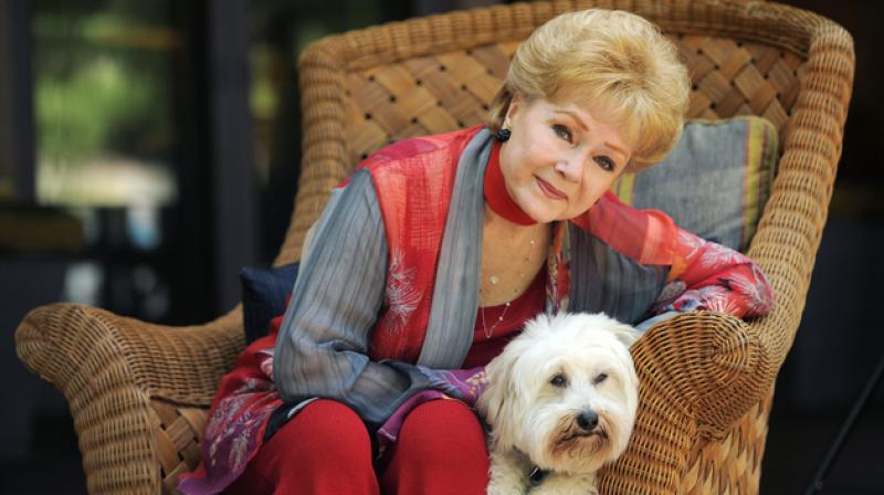 In this file photo, Debbie Reynolds, poses for a portrait with her dog, Dwight, in Beverly Hills, California. (Photo: AP)