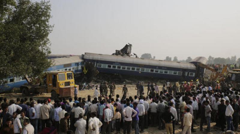 People gather after 14 coaches of an overnight passenger train rolled off the track near Pukhrayan village Kanpur Dehat district, Uttar Pradesh. (Photo: AP)