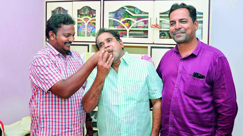 Badminton player K. Srikanths father K.V.S. Krishna is offered sweets by his friends at their residence in Guntur. (Photo: DC)