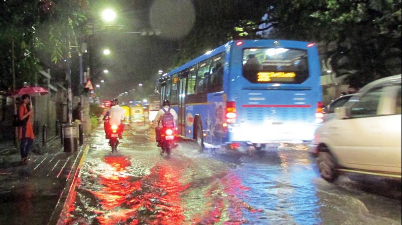 Vehicles pass through the flooded Richmond Circle after rains in Bengaluru on Friday evening. (Photo:KPN)