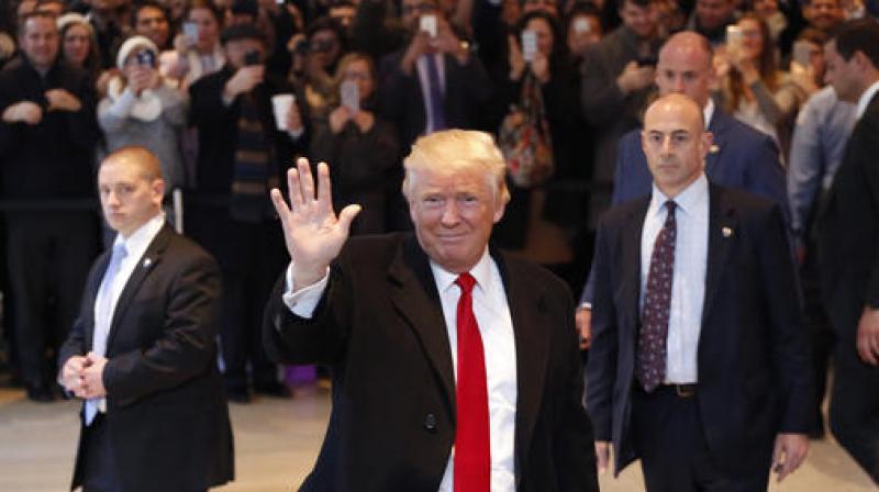 US President-elect Donald Trump waves to the crowd as he leaves the New York Times building following a meeting. (Photo: AP)