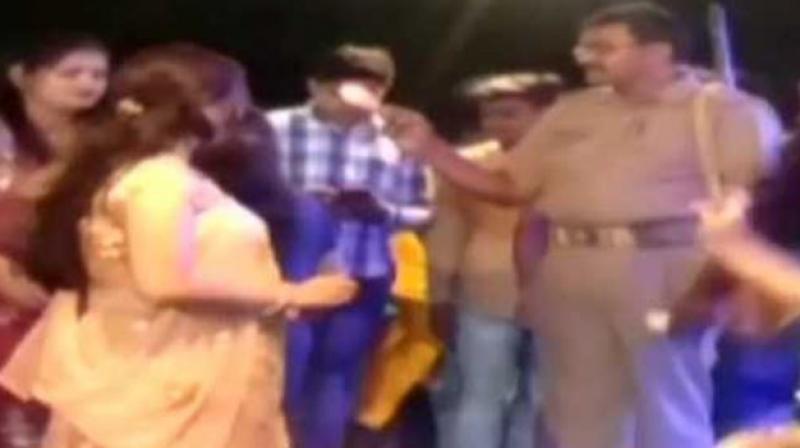 The cops can be seen showering money on dance performers dressed in glittery attires. (Screengrab | ANI)
