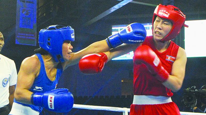 M.C. Mary Kom (left) in action against Kim Hyang Mi of North Korea in their 45-48 kg category semifinal bout at the Aiba Womens World Boxing Championships in New Delhi on Thursday. 	(Photo: Biplab Banerjee)
